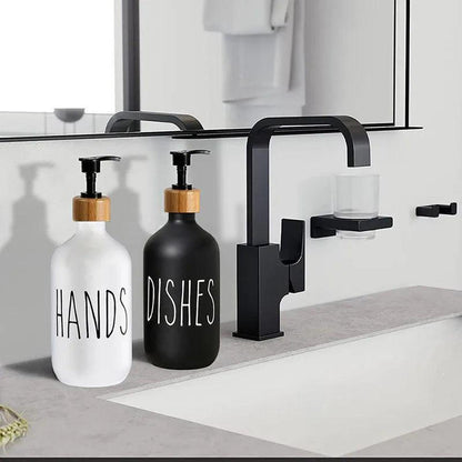 Refillable 500ml white and black soap dispensers with bamboo pumps on a modern bathroom vanity sink.