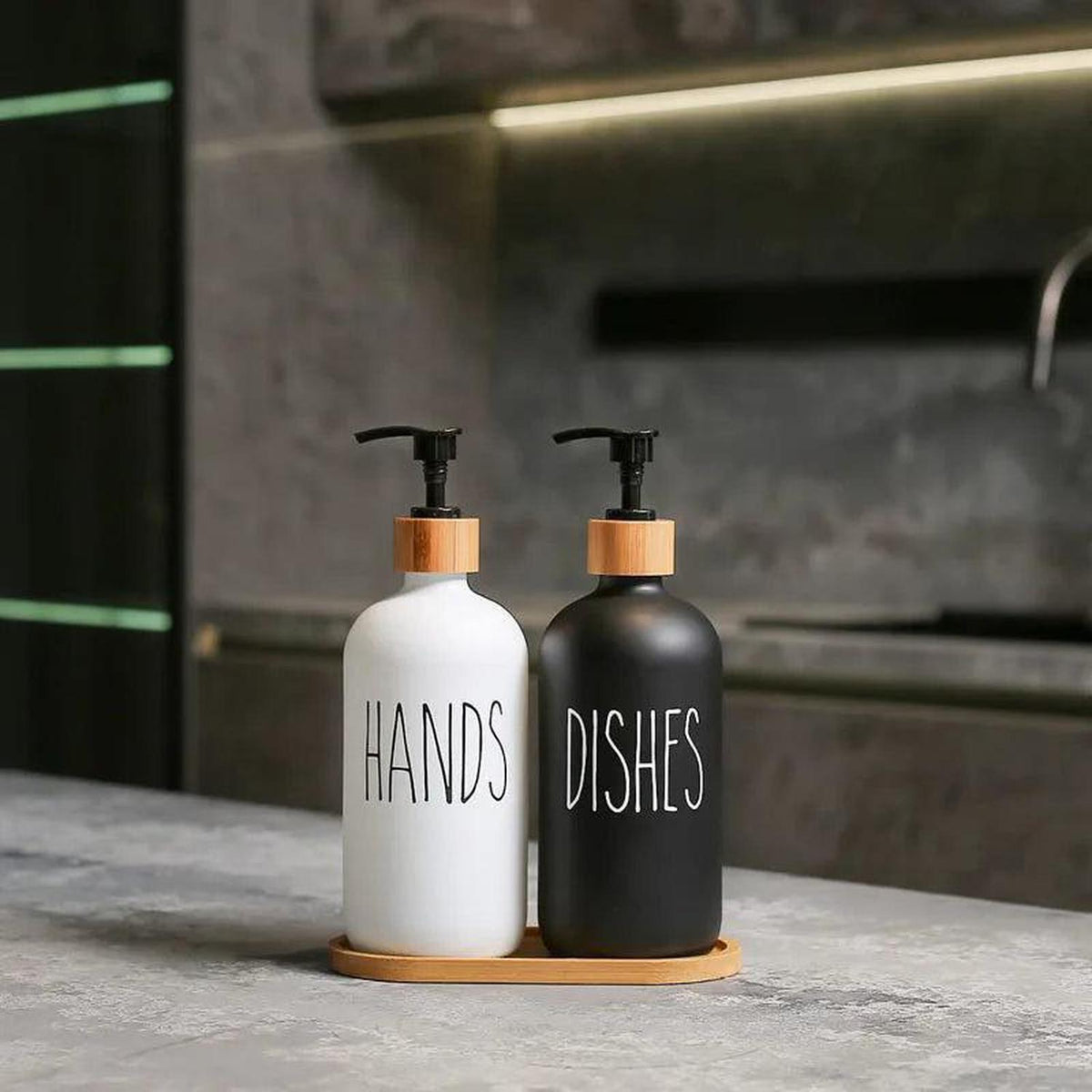 500ml black and white soap dispenser set with bamboo tray and pump lids on a kitchen counter.
