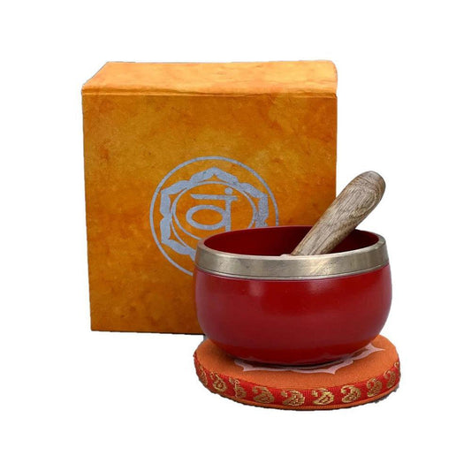 Red brass singing bowl with wooden mallet on an orange cushion, displayed with a matching Sacral Chakra gift box.